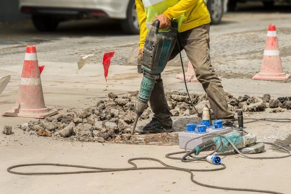 A man breaking up the concrete using jackhammer in Portland, OR